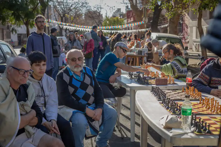 Personas jugando al ajedrez en mesas al aire libre